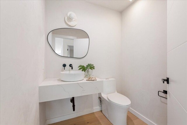 902 Challenger St, Lakeway, TX 78734 - bathroom featuring a sink, toilet, wood finished floors, and baseboards