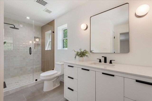 902 Challenger St, Lakeway, TX 78734 - bathroom featuring vanity, toilet, tile patterned flooring, and a stall shower