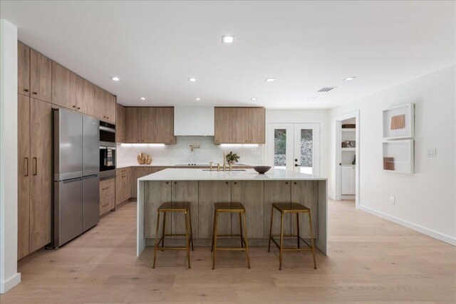 902 Challenger St, Lakeway, TX 78734 - kitchen with appliances with stainless steel finishes, modern cabinets, a sink, light wood finished floors, and recessed lighting