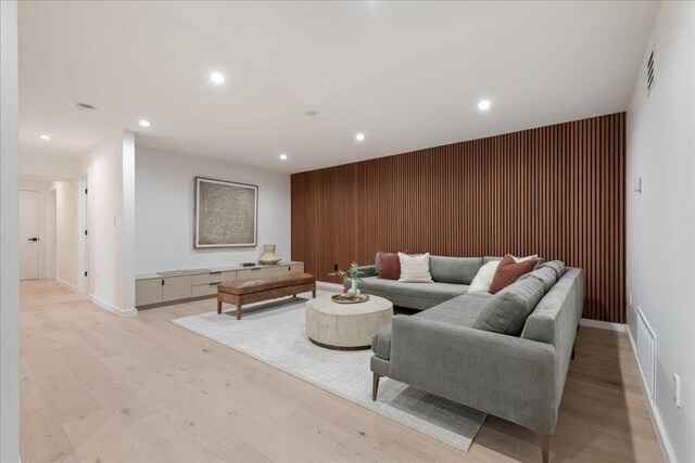 902 Challenger St, Lakeway, TX 78734 - living room featuring an accent wall, recessed lighting, light wood-type flooring, baseboards, and wood walls