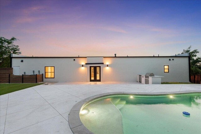902 Challenger St, Lakeway, TX 78734 - back of property at dusk with french doors, a patio, and stucco siding