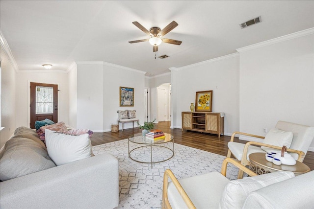 104 Lucky Clover Ln, Hutto, TX 78634 - living room featuring wood finished floors, a ceiling fan, crown molding, arched walkways, and baseboards
