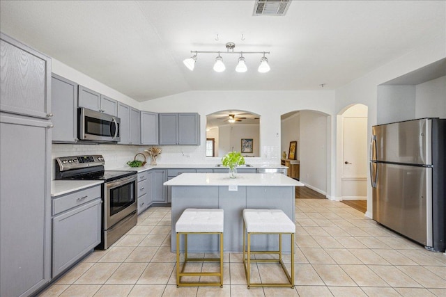104 Lucky Clover Ln, Hutto, TX 78634 - kitchen featuring appliances with stainless steel finishes, gray cabinetry, light tile patterned floors, light countertops, and tasteful backsplash