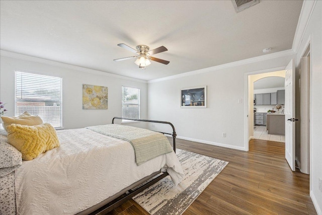 104 Lucky Clover Ln, Hutto, TX 78634 - bedroom with arched walkways, crown molding, baseboards, wood finished floors, and ceiling fan
