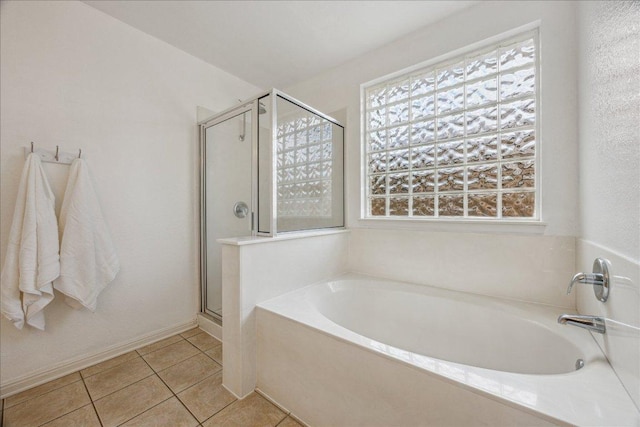 104 Lucky Clover Ln, Hutto, TX 78634 - bathroom with a bath, healthy amount of natural light, a shower stall, and tile patterned flooring