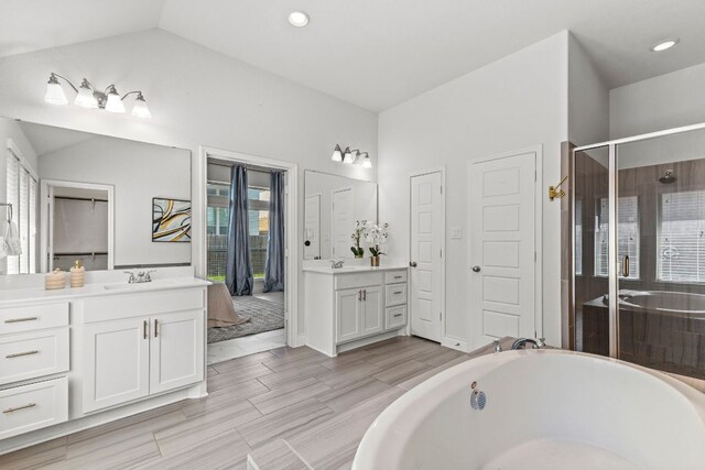 217 Magdalene Way, Liberty Hill, TX 78642 - bathroom with two vanities, a bath, a stall shower, recessed lighting, and lofted ceiling