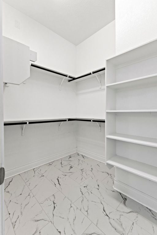217 Magdalene Way, Liberty Hill, TX 78642 - spacious closet featuring marble look tiles