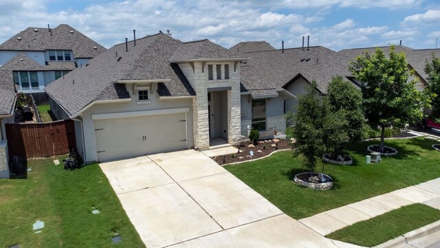 217 Magdalene Way, Liberty Hill, TX 78642 - view of front of house featuring a shingled roof, stone siding, driveway, an attached garage, and stucco siding