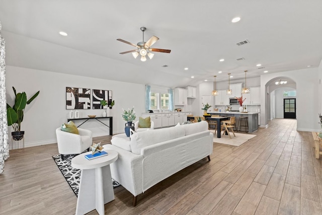 217 Magdalene Way, Liberty Hill, TX 78642 - living area featuring arched walkways, a ceiling fan, light wood finished floors, recessed lighting, and lofted ceiling