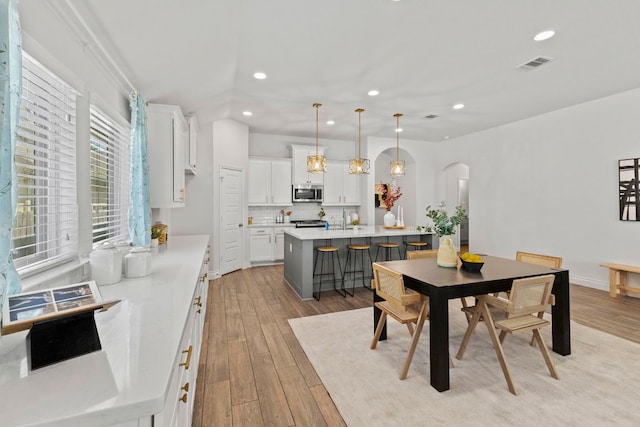 217 Magdalene Way, Liberty Hill, TX 78642 - dining area featuring arched walkways, recessed lighting, and light wood-style floors