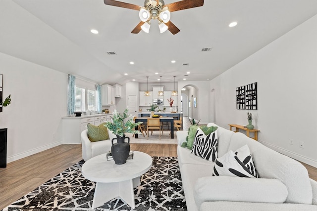 217 Magdalene Way, Liberty Hill, TX 78642 - living room with light wood finished floors, a ceiling fan, recessed lighting, and arched walkways
