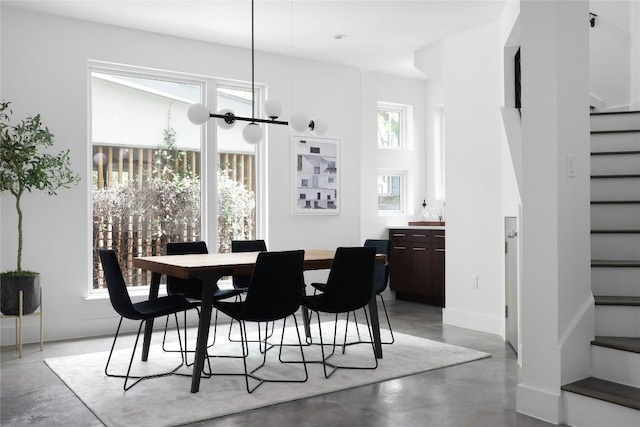 611 Fletcher St, Austin, TX 78704 - dining space with finished concrete flooring, stairway, and baseboards