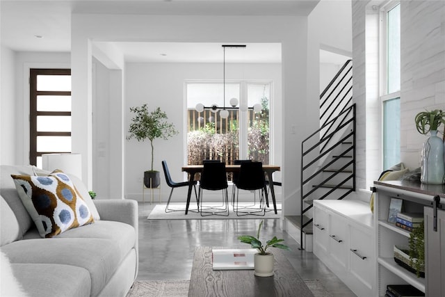 611 Fletcher St, Austin, TX 78704 - living room featuring stairway, healthy amount of natural light, a chandelier, and concrete flooring