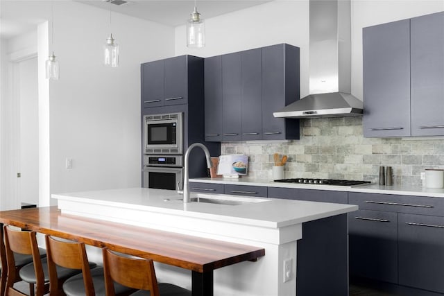611 Fletcher St, Austin, TX 78704 - kitchen featuring wall chimney range hood, stainless steel appliances, a sink, decorative backsplash, and light countertops