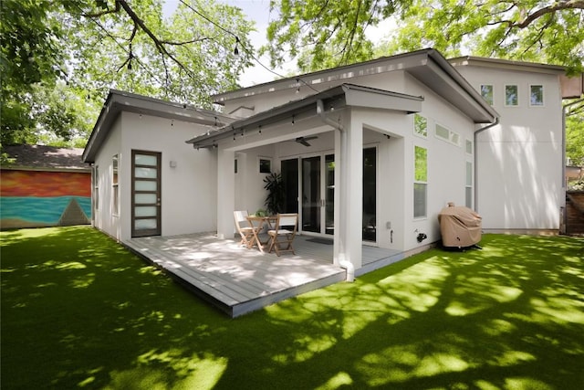 611 Fletcher St, Austin, TX 78704 - rear view of property featuring stucco siding, a wooden deck, a yard, and a ceiling fan