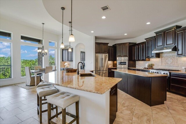 598 Naples Ln, Austin, TX 78737 - kitchen with a sink, stainless steel appliances, a large island, under cabinet range hood, and backsplash