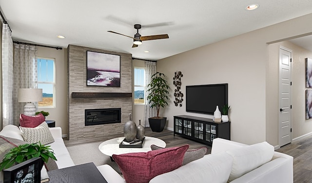20406 Stelfox St, Manor, TX 78653 - living room featuring ceiling fan, a tile fireplace, baseboards, recessed lighting, and wood finished floors