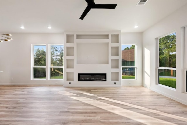 121 Mokolii Ct, Bastrop, TX 78602 - unfurnished living room featuring a ceiling fan, light wood-style flooring, a glass covered fireplace, recessed lighting, and baseboards