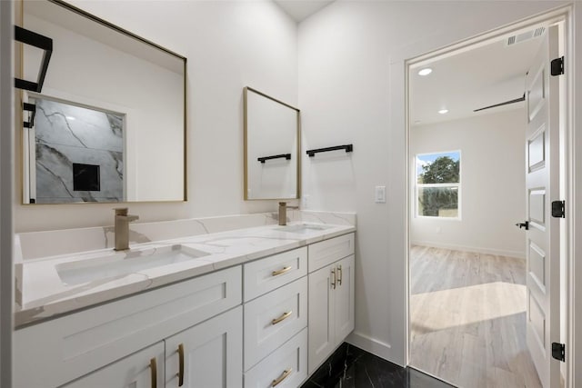 121 Mokolii Ct, Bastrop, TX 78602 - bathroom featuring double vanity, baseboards, marble finish flooring, and recessed lighting