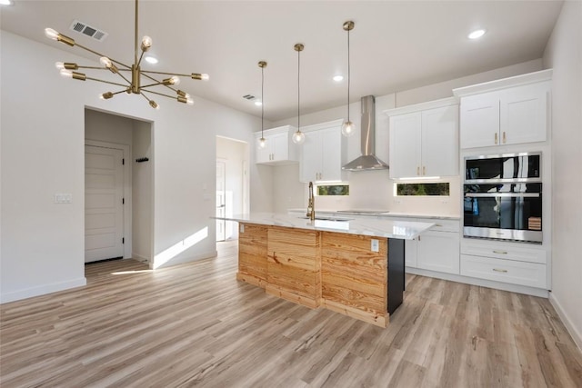 121 Mokolii Ct, Bastrop, TX 78602 - kitchen with wall chimney exhaust hood, light wood-type flooring, white cabinetry, a sink, and recessed lighting