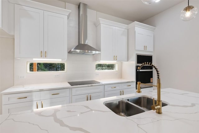 121 Mokolii Ct, Bastrop, TX 78602 - kitchen with wall chimney exhaust hood, black electric cooktop, white cabinets, decorative backsplash, and a sink