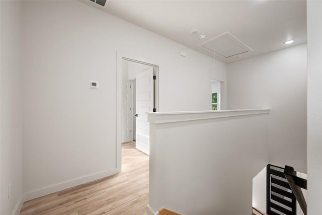 121 Mokolii Ct, Bastrop, TX 78602 - hallway with attic access, an upstairs landing, light wood-style floors, and baseboards