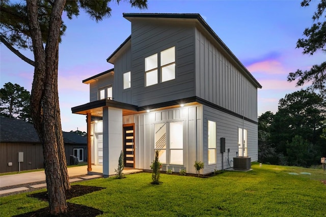 121 Mokolii Ct, Bastrop, TX 78602 - back of house at dusk featuring a yard and board and batten siding