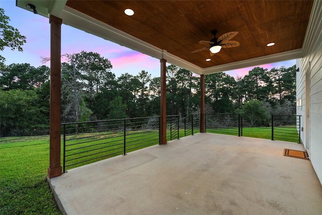 121 Mokolii Ct, Bastrop, TX 78602 - patio terrace at dusk featuring ceiling fan, a yard, a patio area, and view of wooded area