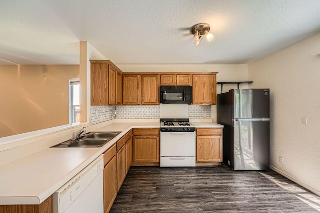 16321 Hamilton Point Cir, Manor, TX 78653 - kitchen with white appliances, a sink, decorative backsplash, dark wood-style flooring, and brown cabinets