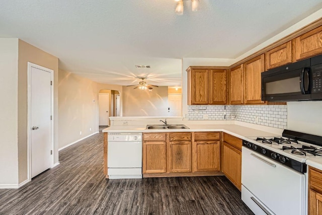 16321 Hamilton Point Cir, Manor, TX 78653 - kitchen featuring white appliances, a sink, arched walkways, tasteful backsplash, and brown cabinetry