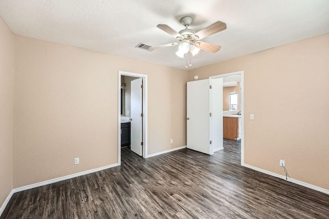 16321 Hamilton Point Cir, Manor, TX 78653 - unfurnished bedroom with dark wood-type flooring, baseboards, ceiling fan, and connected bathroom