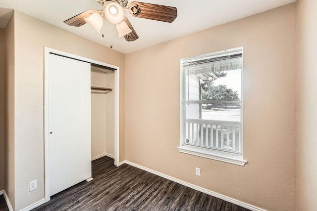 16321 Hamilton Point Cir, Manor, TX 78653 - unfurnished bedroom featuring dark wood-style floors, a closet, baseboards, and a ceiling fan