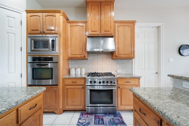 9904 Chester Cv, Austin, TX 78750 - kitchen featuring stainless steel appliances, range hood, light stone countertops, decorative backsplash, and light tile patterned floors
