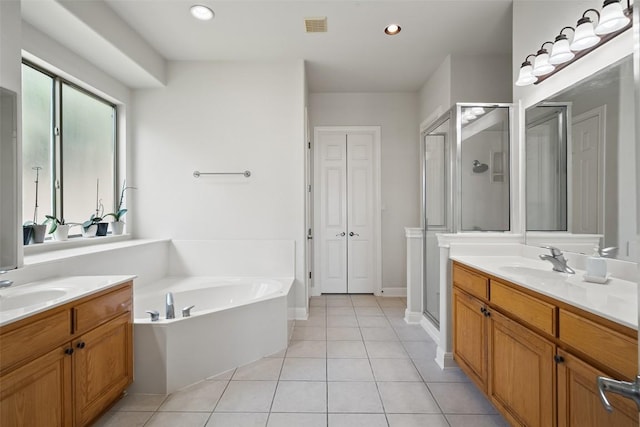 9904 Chester Cv, Austin, TX 78750 - full bathroom featuring a shower stall, a bath, tile patterned flooring, two vanities, and recessed lighting