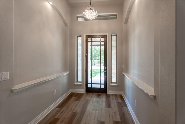 503 Fire Dance, Horseshoe Bay, TX 78657 - foyer entrance with arched walkways, wood finished floors, baseboards, a chandelier, and a high ceiling
