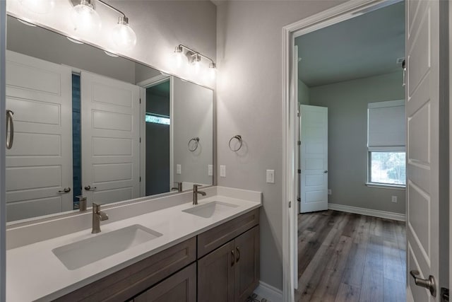 503 Fire Dance, Horseshoe Bay, TX 78657 - bathroom featuring double vanity, baseboards, and wood finished floors