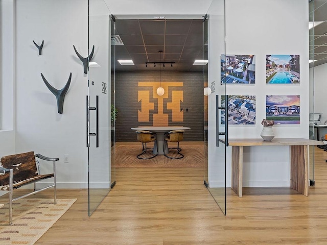 630 Central Pkwy Unit 1213, New Braunfels, TX 78130 - hallway with wood finished floors, baseboards, rail lighting, brick wall, and an accent wall
