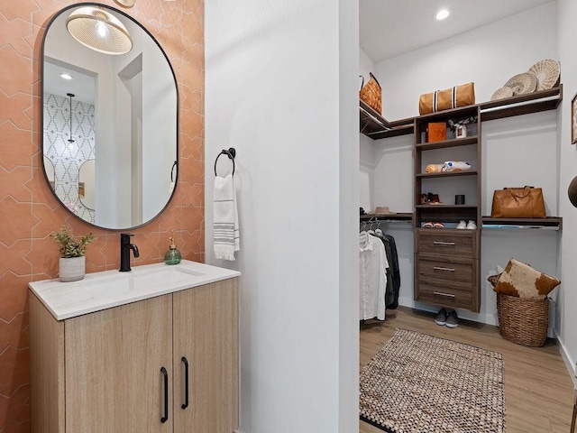 630 Central Pkwy Unit 1213, New Braunfels, TX 78130 - bathroom with wood finished floors, vanity, a walk in closet, baseboards, and recessed lighting