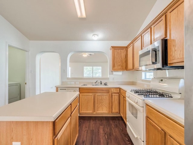 581 Sampson, Kyle, TX 78640 - kitchen featuring white gas stove, stainless steel microwave, a sink, washer / clothes dryer, and light countertops