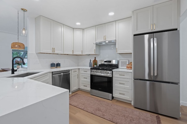 1607 Forest St, Georgetown, TX 78626 - kitchen featuring appliances with stainless steel finishes, a sink, light stone countertops, hanging light fixtures, and white cabinets