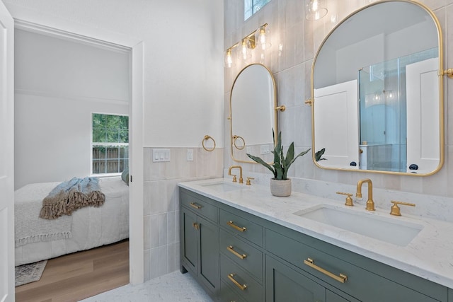 1607 Forest St, Georgetown, TX 78626 - full bathroom with tile walls, ensuite bath, double vanity, and wood finished floors