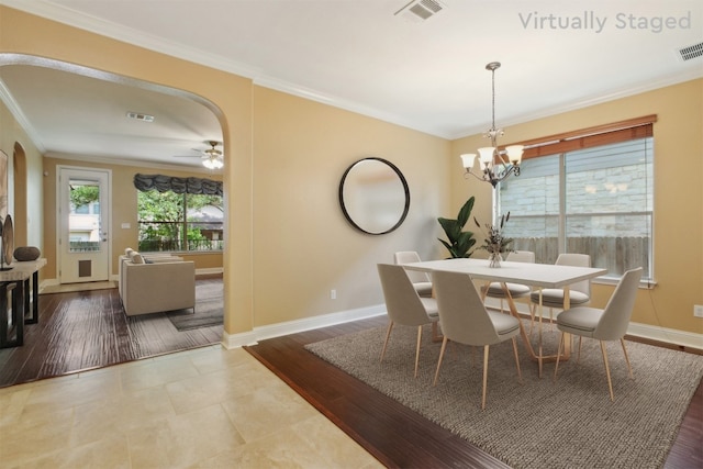 12109 Bryony Dr, Austin, TX 78739 - dining space featuring arched walkways, baseboards, ornamental molding, a chandelier, and ceiling fan