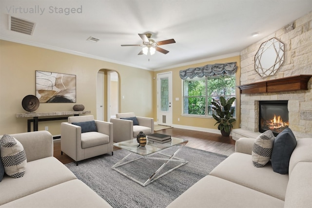 12109 Bryony Dr, Austin, TX 78739 - living room featuring arched walkways, wood finished floors, a fireplace, ornamental molding, and a ceiling fan