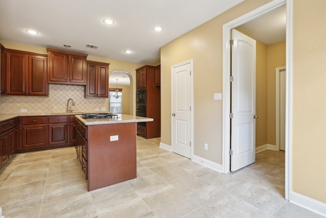 12109 Bryony Dr, Austin, TX 78739 - kitchen featuring arched walkways, black appliances, a center island, decorative backsplash, and a sink