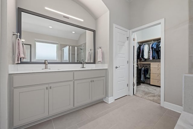108 Panzano Dr, Georgetown, TX 78628 - full bath with a shower stall, a spacious closet, double vanity, tile patterned flooring, and vaulted ceiling