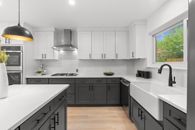 813 Cardiff Dr, Austin, TX 78745 - kitchen featuring wall chimney exhaust hood, appliances with stainless steel finishes, a sink, backsplash, and light countertops