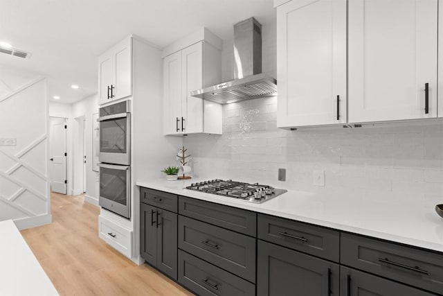813 Cardiff Dr, Austin, TX 78745 - kitchen with wall chimney exhaust hood, stainless steel appliances, white cabinets, light countertops, and recessed lighting