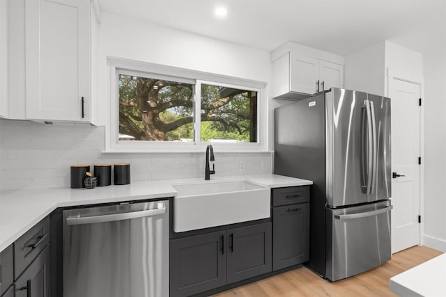 813 Cardiff Dr, Austin, TX 78745 - kitchen featuring stainless steel appliances, a sink, white cabinets, light wood-type flooring, and recessed lighting