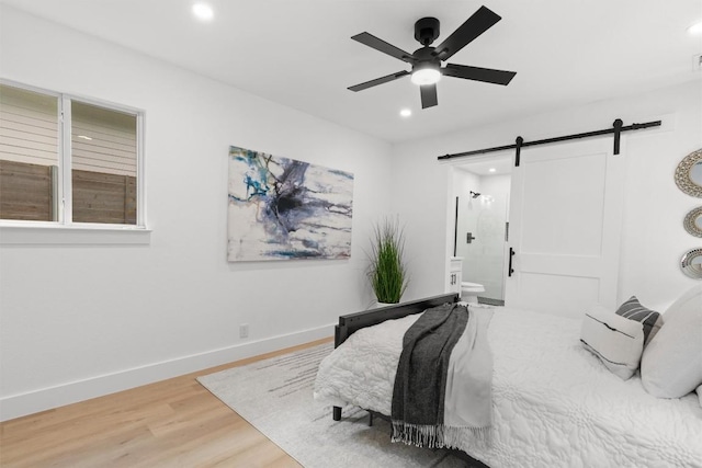 813 Cardiff Dr, Austin, TX 78745 - bedroom with a barn door, recessed lighting, light wood-type flooring, ensuite bathroom, and baseboards