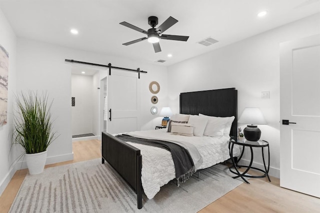 813 Cardiff Dr, Austin, TX 78745 - bedroom with a barn door, light wood-type flooring, recessed lighting, baseboards, and ceiling fan